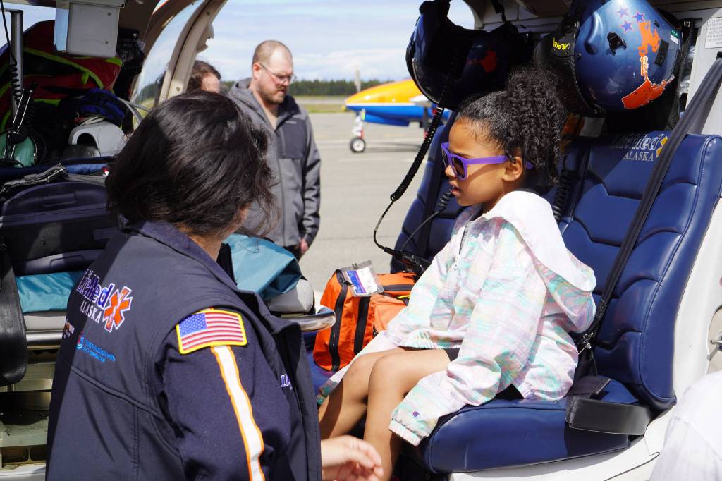 A representative of LifeMed Alaska answers questions from a young attendee at the Kenai Peninsula Air Fair on Saturday, June 10, 2023, at the Kenai Municipal Airport in Kenai, Alaska. (Jake Dye/Peninsula Clarion)
