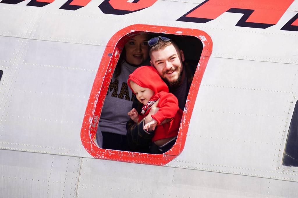 Attendees look out from a window inside a large plane displayed at the Kenai Peninsula Air Fair on Saturday, June 10, 2023, at the Kenai Municipal Airport in Kenai, Alaska. (Jake Dye/Peninsula Clarion)