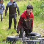 Muddy runners move down the Tsalteshi Trails Porcupine Loop in Soldotna, Alaska, as they participate in the KDLL Mud Run on Friday, June 16, 2023. (Jake Dye/Peninsula Clarion)