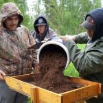 Marcus Wong sifts through a soil sample poured by Michael Bernard at an archeological site near Nikiski, Alaska, on Tuesday, June 27, 2023. (Jake Dye/Peninsula Clarion)