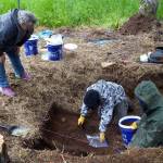 One of the interns working with Salamatof Tribe Duhdeldiht Youth Services collects a soil sample at an archeological site near Nikiski, Alaska, on Tuesday, June 27, 2023. (Jake Dye/Peninsula Clarion)