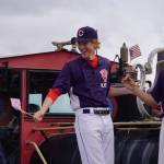 Players for the American Legion Twins smile and wave as the Fourth of July Parade moves down South Willow Street in Kenai, Alaska on Tuesday, July 4, 2023. (Jake Dye/Peninsula Clarion)
