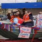 Representatives of the U.S. Coast Guard Auxillary wave as the Fourth of July Parade moves down the Kenai Spur Highway in Kenai, Alaska on Tuesday, July 4, 2023. (Jake Dye/Peninsula Clarion)