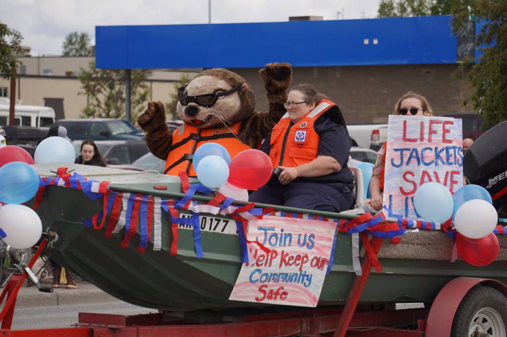 Representatives of the U.S. Coast Guard Auxillary wave as the Fourth of July Parade moves down the Kenai Spur Highway in Kenai, Alaska on Tuesday, July 4, 2023. (Jake Dye/Peninsula Clarion)