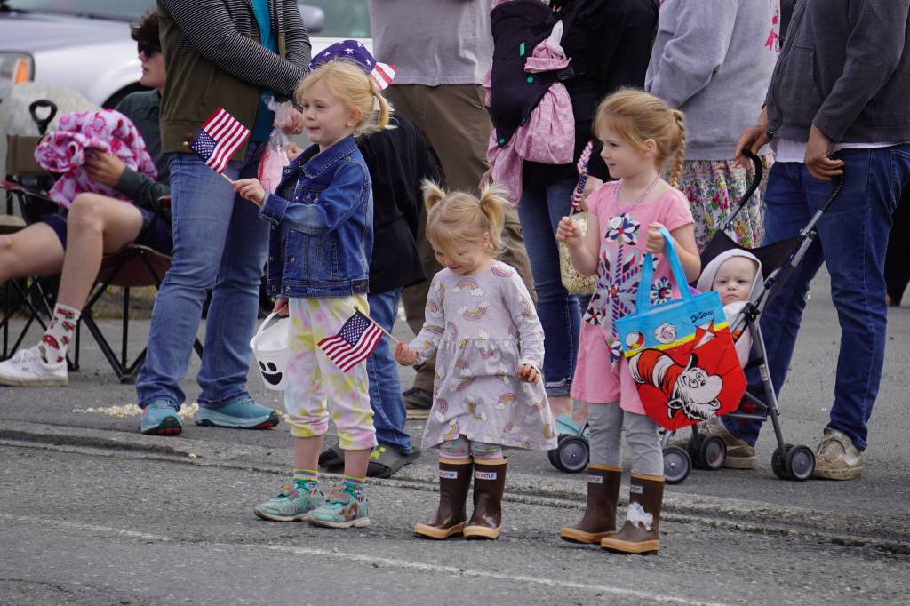 Children wave flags as the Fourth of July Parade moves down South Willow Street in Kenai, Alaska on Tuesday, July 4, 2023. (Jake Dye/Peninsula Clarion)