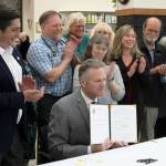 Gov. Mike Dunleavy holds a copy of newly signed House Bill 56, exempting Alaska veterinarians from the states prescription drug monitoring program at a bill signing event at Twin Cities Veterinary Clinic on Thursday, July 6, 2023 in Soldotna, Alaska. (Ashlyn OHara/Peninsula Clarion)