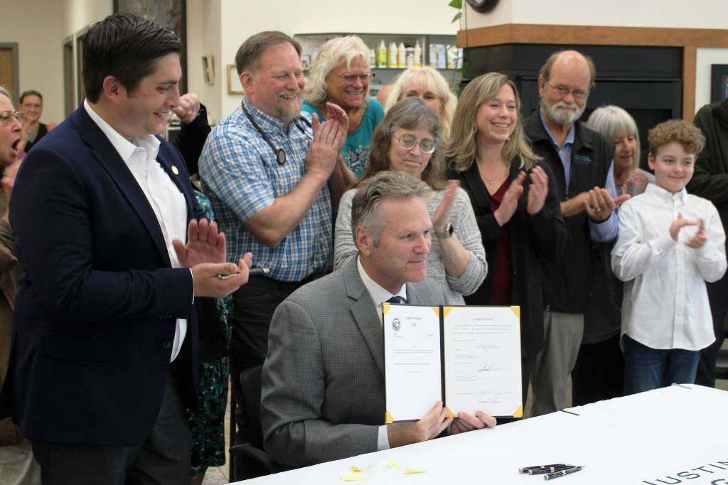 Gov. Mike Dunleavy holds a copy of newly signed House Bill 56, exempting Alaska veterinarians from the states prescription drug monitoring program at a bill signing event at Twin Cities Veterinary Clinic on Thursday, July 6, 2023 in Soldotna, Alaska. (Ashlyn OHara/Peninsula Clarion)