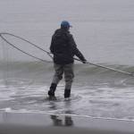Betty Hatch wades out into the mouth of the Kenai River with a dipnet in hand on Monday, July 10, 2023, at the Kenai Beach in Kenai, Alaska. (Jake Dye/Peninsula Clarion)
