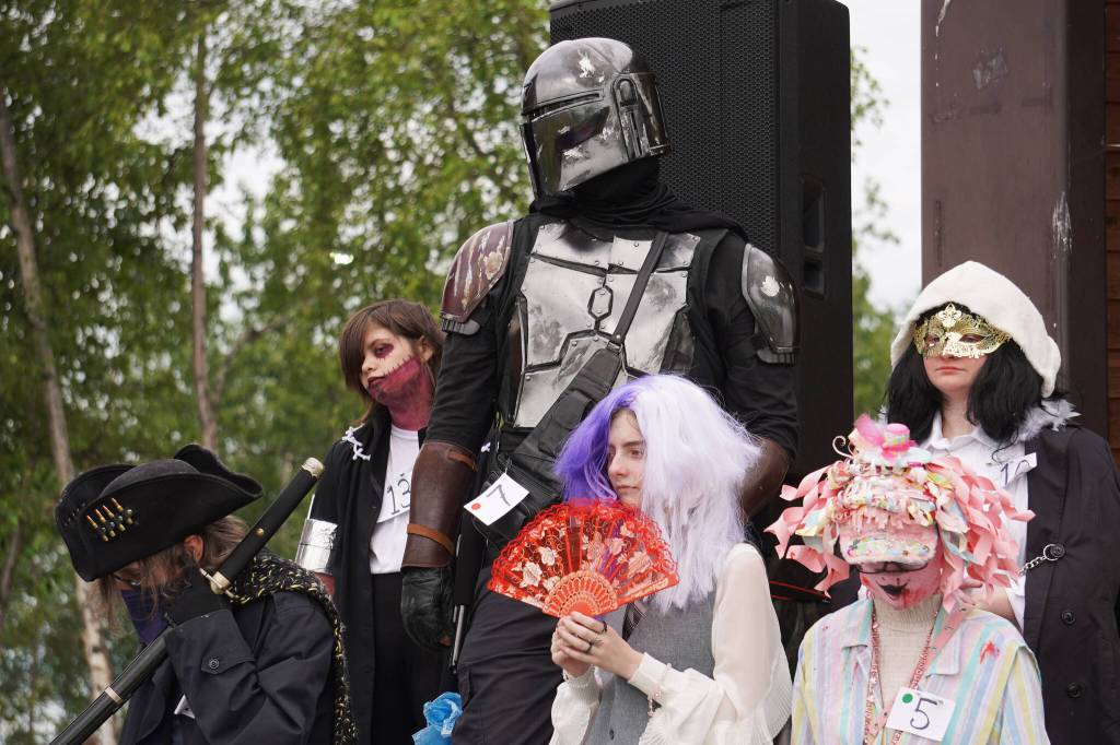 Cosplayers stand together while judges tabulate the results of the Kenai Performers Cosplay Contest, part of the Progress Days Fair at Soldotna Creek Park in Soldotna, Alaska, on Friday, July 21, 2023. (Jake Dye/Peninsula Clarion)