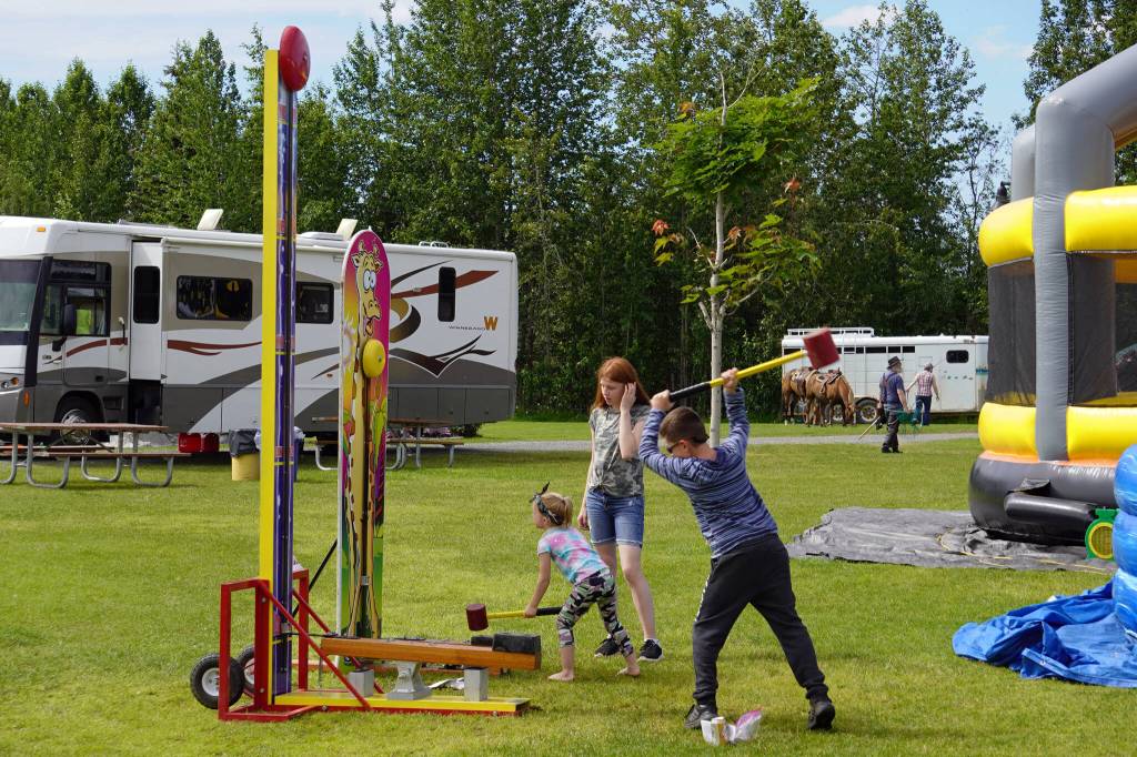 Alexis Jaeger and Chase Koppedge swing hammers at the Progress Days Fair at Soldotna Creek Park in Soldotna, Alaska, on Friday, July 21, 2023. (Jake Dye/Peninsula Clarion)