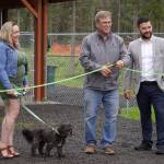 Lena Wissner, Brian Gabriel, and Tyler Best cut the ribbon at a grand opening ceremony for the Kenai Bark Park in Kenai, Alaska, on Friday, July 28, 2023. (Jake Dye/Peninsula Clarion)