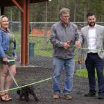 Lena Wissner, Brian Gabriel, and Tyler Best cut the ribbon at a grand opening ceremony for the Kenai Bark Park in Kenai, Alaska, on Friday, July 28, 2023. (Jake Dye/Peninsula Clarion)