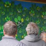 Attendees of the grand opening of the Kenai Bark Park in Kenai, Alaska, view a wall with the names of contributors for the project on Friday, July 28, 2023. (Jake Dye/Peninsula Clarion)