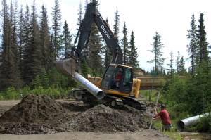Contractors for the Kenai Peninsula Borough install a culvert at the intersection of Patrick Dr. and Bjerke St. to mitigate flooding off of Kalifornsky Beach Rd. on Friday, July 21, 2023 near Kenai, Alaska. (Ashlyn OHara/Peninsula Clarion)