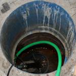 A pump sucks water out of a hole in Marcus Ashkenasys garage on Monday, July 24, 2023 near Kenai, Alaska. (Ashlyn OHara/Peninsula Clarion)