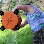 Marcus Ashkenasy dumps water pumped from his house into his front yard on Monday, July 24, 2023 near Kenai, Alaska. (Ashlyn OHara/Peninsula Clarion)