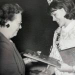 photo courtesy of the Smith Family Collection
Mary Ruth Nidiffer (Miss Alaska 1965) hands Mable Smith a plaque of appreciation for Smiths service to the Alaska Purchase Centennial Celebration committee.