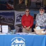 Max Mitchell and Robert Archibald man a booth for the Prince William Sound Regional Citizens Advisory Council at Salmonfest in Ninilchik, Alaska, on Friday, Aug. 4, 2023. (Jake Dye/Peninsula Clarion)