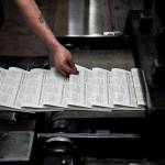 Mike Tullar grabs a Herald to check over as the first papers roll off the press on Wednesday, March 30, 2022 in Everett, Washington. (Olivia Vanni / The Herald)