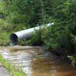 Water pools near at the intersection of Patrick Drive and Bjerke Street, where contractors for the Kenai Peninsula Borough install a culvert to mitigate flooding off of Kalifornsky Beach Road on Friday, July 21, 2023 near Kenai, Alaska. (Ashlyn OHara/Peninsula Clarion) ,