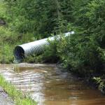 Ashlyn OHara/Peninsula Clarion
Water pools near at the intersection of Patrick Drive and Bjerke Street, where contractors for the Kenai Peninsula Borough install a culvert to mitigate flooding off of Kalifornsky Beach Road on July 21 near Kenai.