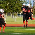 Kenais Cole Langham, William Wilson and Bobby Hayes celebrate a touchdown during a season opening game at Ed Hollier Field in Kenai, Alaska, on Friday, Aug. 11, 2023. (Jake Dye/Peninsula Clarion)