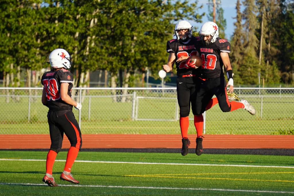 Kenais Cole Langham, William Wilson and Bobby Hayes celebrate a touchdown during a season opening game at Ed Hollier Field in Kenai, Alaska, on Friday, Aug. 11, 2023. (Jake Dye/Peninsula Clarion)