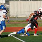 Kenais Bobby Hayes moves down the field with the ball, being dragged down by Kodiaks Steven Pascua, during a season opening game at Ed Hollier Field in Kenai, Alaska, on Friday, Aug. 11, 2023. (Jake Dye/Peninsula Clarion)