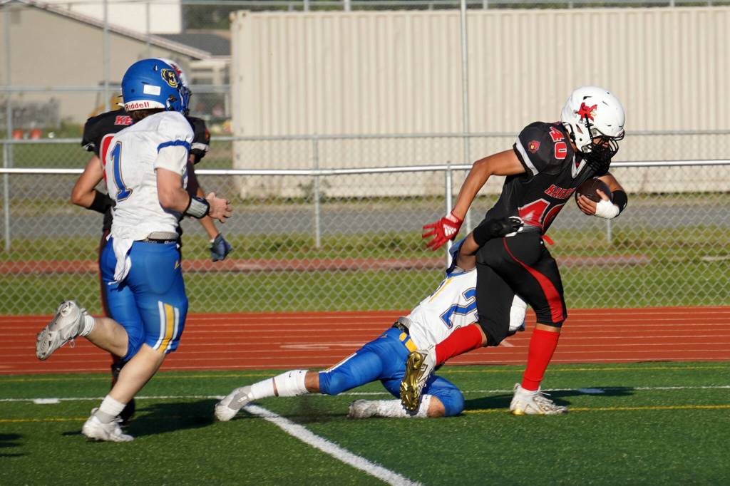 Kenais Bobby Hayes moves down the field with the ball, being dragged down by Kodiaks Steven Pascua, during a season opening game at Ed Hollier Field in Kenai, Alaska, on Friday, Aug. 11, 2023. (Jake Dye/Peninsula Clarion)