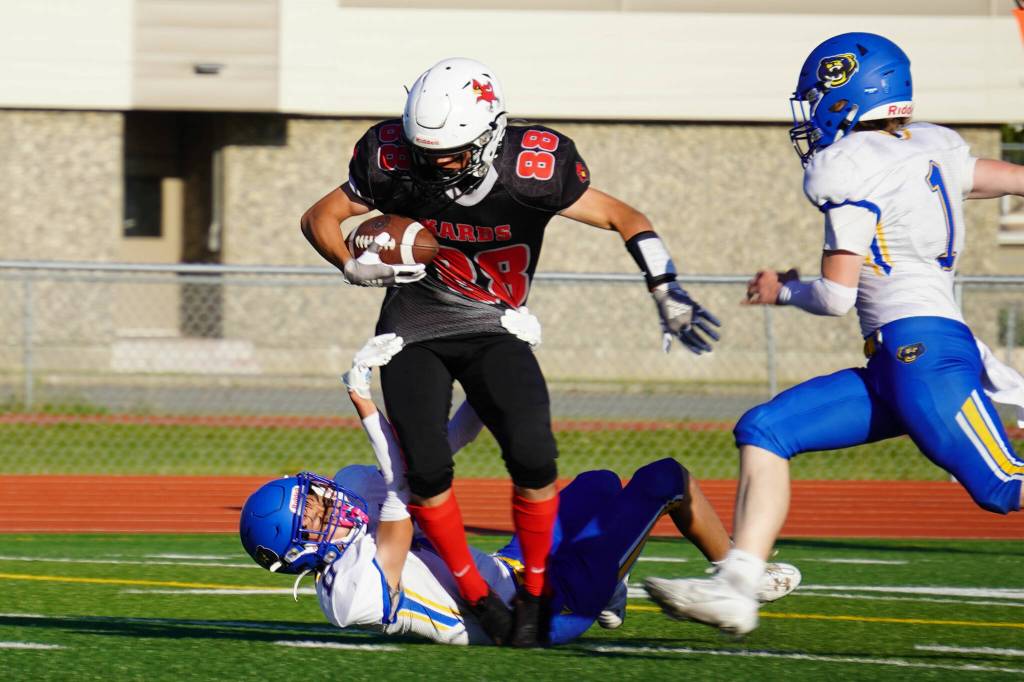 Kenais Sawyer Vann is dragged down by Kodiaks Hezekiah Nidoy during a season opening game at Ed Hollier Field in Kenai, Alaska, on Friday, Aug. 11, 2023. (Jake Dye/Peninsula Clarion)