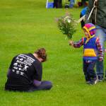 Mollie Messick receives flowers from her child after finishing the 34th Annual Kenai Peninsula Violence Free Community Run in Kenai, Alaska, on Saturday, Aug. 12, 2023. (Jake Dye/Peninsula Clarion)