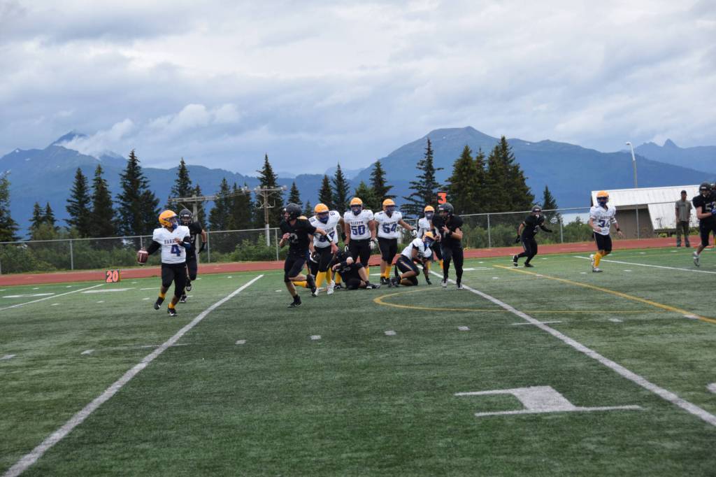 Barrows Dwight Unutoa prepares to pass the ball downfield to Ethan Goodwin, who will carry it to the Whalers first touchdown of the game on Saturday, Aug. 12, 2023 in Homer, Alaska (Delcenia Cosman/Homer News)
