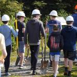 Triumvirate Theatre performers, equipped with hard hats and shovels, proceed to the future home of the Triumvirate Theatre in Kenai, Alaska for a ceremonial groundbreaking on Saturday, Aug. 19, 2023. (Jake Dye/Peninsula Clarion)