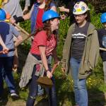 Triumvirate Theatre performers shovel dirt during a ceremonial groundbreaking at the future home of Triumvirate Theatre in Kenai, Alaska, on Saturday, Aug. 19, 2023. (Jake Dye/Peninsula Clarion)