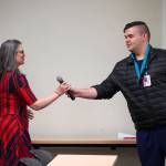 Ana Monyahan takes the microphone from Kenneth Coghill II after his speech at a graduation ceremony at Central Peninsula Hospital in Soldotna, Alaska, on Friday, Aug. 25, 2023. (Jake Dye/Peninsula Clarion)