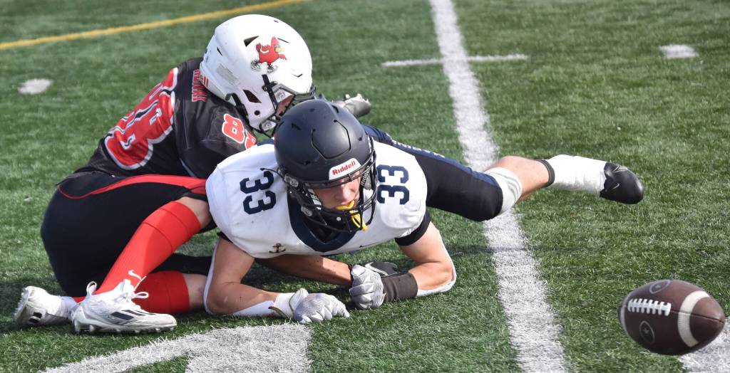 Homers Jake Tappan is taken down by Kenai Centrals Sawyer Vann while a live ball lies on the field Saturday, Sept. 2, 2023, at Ed Hollier Field at Kenai Central High School in Kenai, Alaska. The Kardinals would recover the ball. (Photo by Jeff Helminiak/Peninsula Clarion)