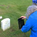 Victoria Askin photographs a headstone in the Kenai Cemetery as part of a city imaging project on Friday, Sept. 8, 2023 in Kenai, Alaska. (Ashlyn OHara/Peninsula Clarion)