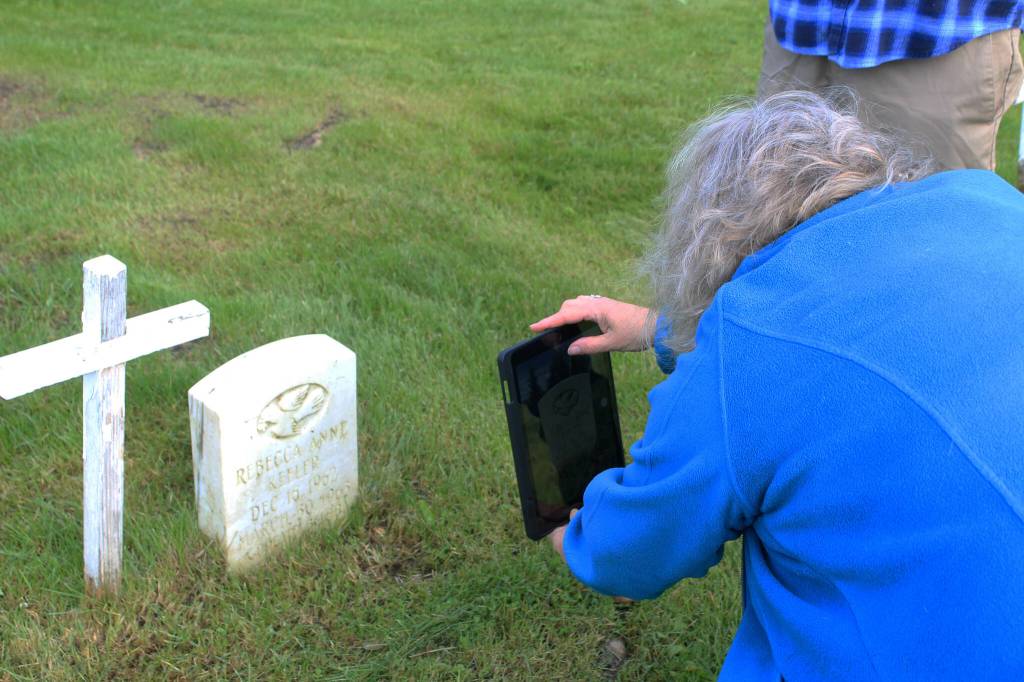 Victoria Askin photographs a headstone in the Kenai Cemetery as part of a city imaging project on Friday, Sept. 8, 2023 in Kenai, Alaska. (Ashlyn OHara/Peninsula Clarion)