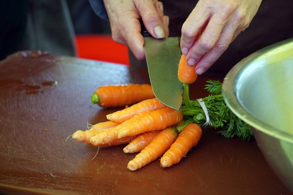 Carrots are prepared for preservation at the Harvest Moon Local Food Festivals Fermentation Station at Soldotna Creek Park in Soldotna, Alaska, on Saturday, Sept. 16, 2023. (Jake Dye/Peninsula Clarion)