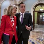 U.S. Sens. Lisa Murkowski and Mitt Romney greet each other outside the chamber at the U.S. Capitol on April 5, 2022. (J. Scott Applewhite / AP file photo)