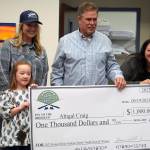 Abigal Craig, youth winner of the Seventh Annual Kenai Silver Salmon Derby, is presented a novelty check by Kenai River Sportfishing Association Executive Director Shannon Martin, City of Kenai Mayor Brian Gabriel, and Kenai Chamber of Commerce Executive Director Samantha Springer at the Kenai Chamber of Commerce and Visitor Center in Kenai, Alaska, on Wednesday, Sept. 20, 2023. (Jake Dye/Peninsula Clarion)