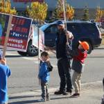Kenai Peninsula Borough Assembly candidate Bill Elam (center) helps his son, James, second from right, wave signs on election day, along with sons William (left), Andrew (second from left) and wife Sandra (right) on Tuesday, Oct. 3, 2023 in Soldotna, Alaska. (Ashlyn OHara/Peninsula Clarion)