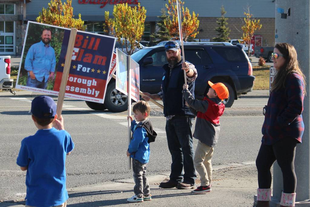 Kenai Peninsula Borough Assembly candidate Bill Elam (center) helps his son, James, second from right, wave signs on election day, along with sons William (left), Andrew (second from left) and wife Sandra (right) on Tuesday, Oct. 3, 2023 in Soldotna, Alaska. (Ashlyn OHara/Peninsula Clarion)