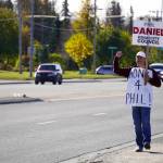 A supporter of Phil Daniel calls on drivers to honk their horns along the Kenai Spur Highway in Kenai, Alaska, during election day on Tuesday, Oct. 3, 2023. (Jake Dye/Peninsula Clarion)