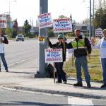 Phil Daniel, left, joins supporters of both himself and Teea Winger in waving signs on the corner of Bridge Access Road and the Kenai Spur Highway in Kenai, Alaska, for election day on Tuesday, Oct. 3, 2023. (Jake Dye/Peninsula Clarion)