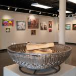 A fire pit crafted by C.O. Rudstrom stands at the center of the gallery, in front of several other pieces included in the Biennial Judged Show at the Kenai Art Center in Kenai, Alaska, on Wednesday, Oct. 4, 2023. (Jake Dye/Peninsula Clarion)