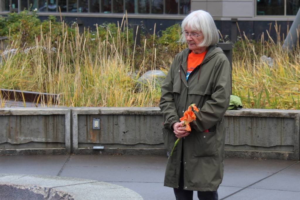 Mary Hunt, a survivor of Holy Cross Mission, holds flowers during an Orange Shirt Day ceremony at Ggugguyni T'uh, "Raven Place," outside the Dena'ina Wellness Center on Friday, Oct. 6, 2023 in Kenai, Alaska. Orange Shirt Day honors indigenous elders who survived and children lost from boarding schools established to detribalize indigenous people. (Ashlyn O'Hara/Peninsula Clarion)