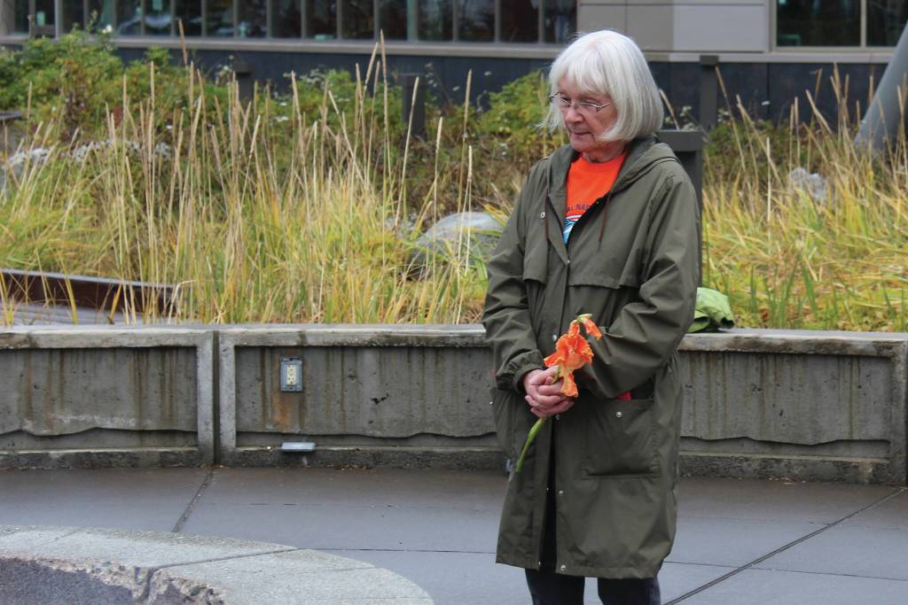 Mary Hunt, a survivor of Holy Cross Mission, holds flowers during an Orange Shirt Day ceremony at Ggugguyni Tuh, Raven Place, outside the Denaina Wellness Center on Oct. 6 in Kenai. (Ashlyn OHara/Peninsula Clarion)