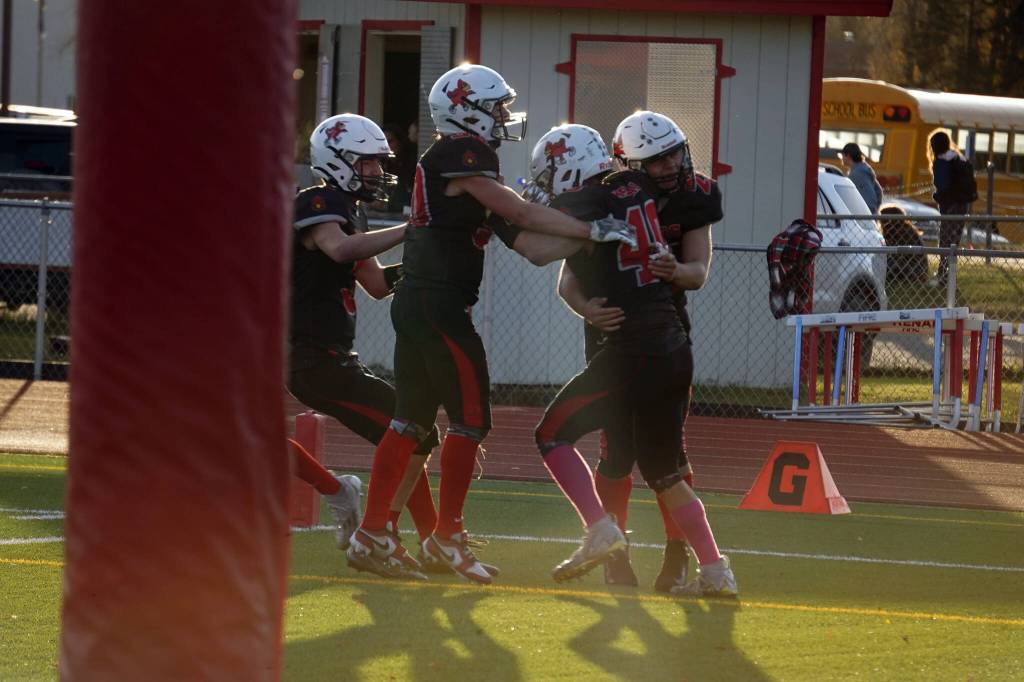 The Kenai Central Kardinals celebrate a game winning touchdown scored by Bobby Hayes during a Division III playoff game at Ed Hollier Field in Kenai, Alaska, on Saturday, Oct. 7, 2023. (Jake Dye/Peninsula Clarion)