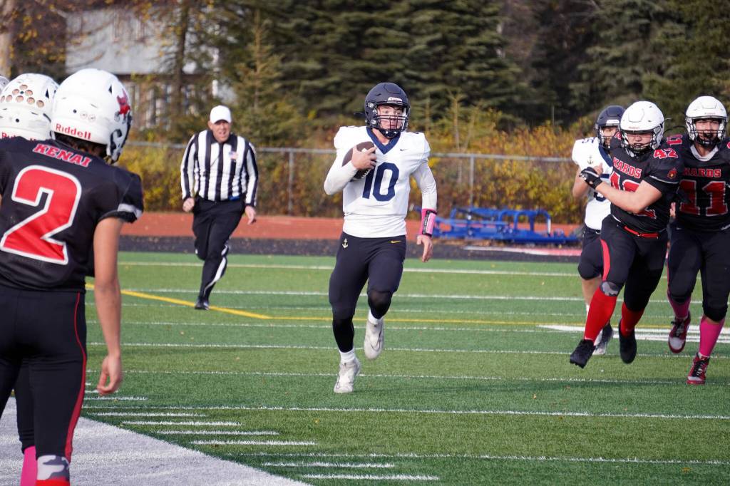 Homers Preston Stanislaw runs with the ball pursued by Kenais Elliot Haakenson during a Division III playoff game at Justin Maile Field in Soldotna, Alaska, on Saturday, Oct. 7, 2023. (Jake Dye/Peninsula Clarion)